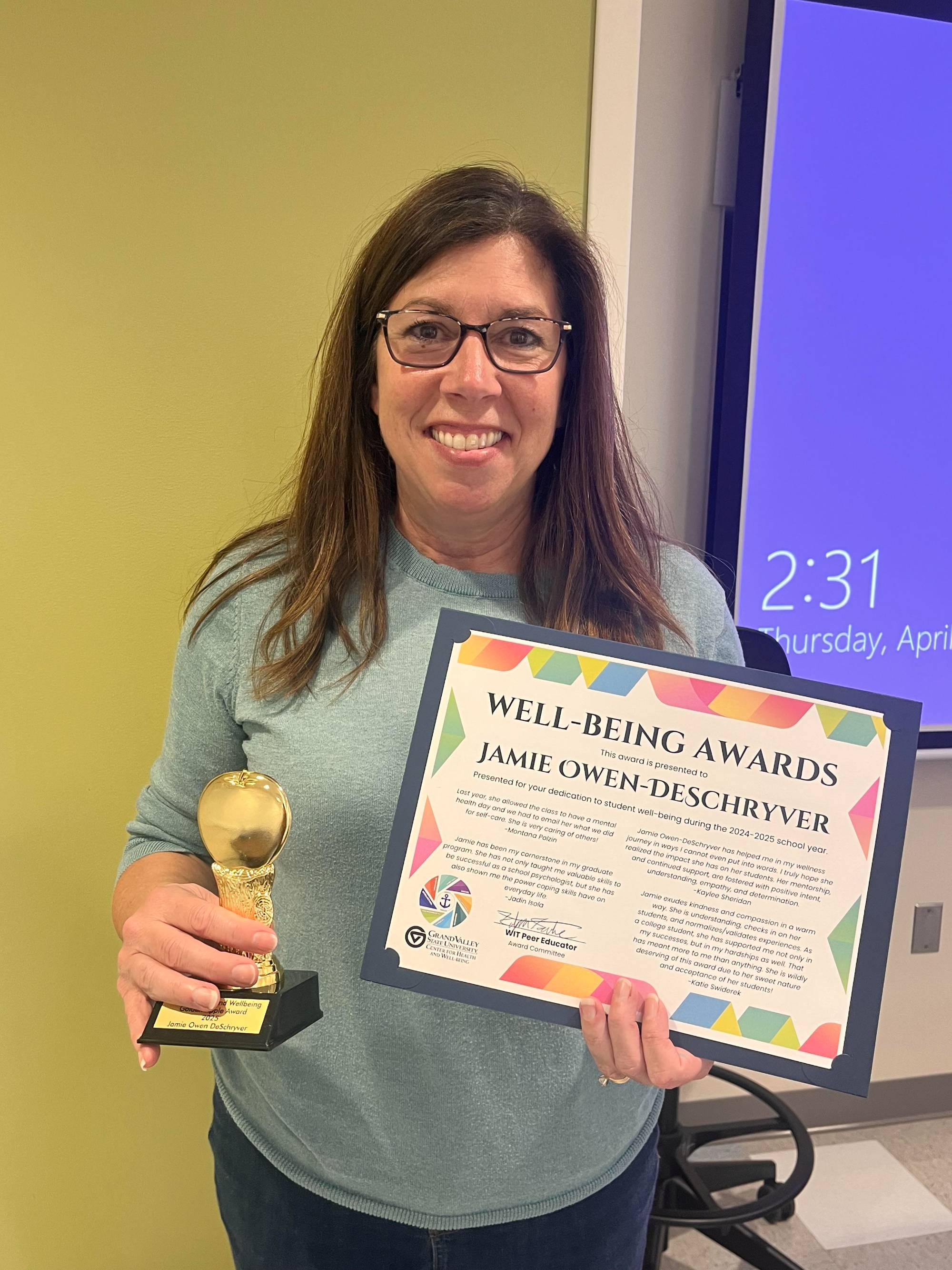 Jamie Owen-Deschryver with golden apple award and certificate